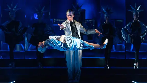 Szene aus Musical "Simsalabim", Zauberer lässt Person vor sich schweben.