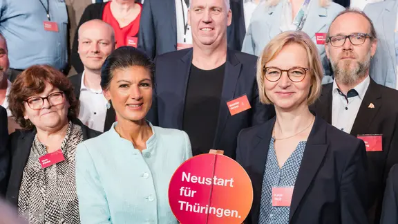 Katja Wolf hält mit Sahra Wagenknecht eine Starterklappe mit der Aufschrift „Neustart für Thüringen“ bei einem Gruppenbild