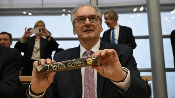 Reiner Haseloff (CDU), Ministerpräsident des Landes Sachsen-Anhalt, hält eine Süßigkeit im Plenarsaal des Landtages von Sachsen-Anhalt. 
