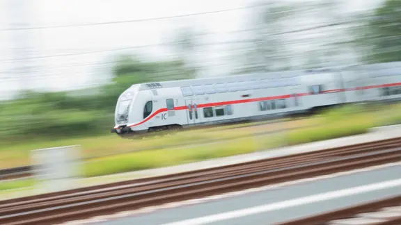 Ein doppelstöckiger Intercity 2 (IC2) fährt über Schienen in der Region Hannover. 