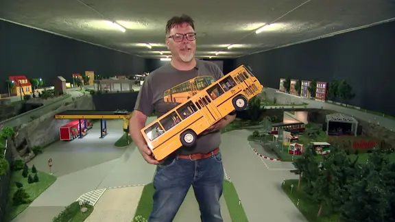Modellbauer hält Busmodell