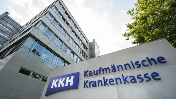Vor einem Bürogebäude stehen auf einer Betonwand die Buchstaben KKH Kaufmännische Krankenkasse.