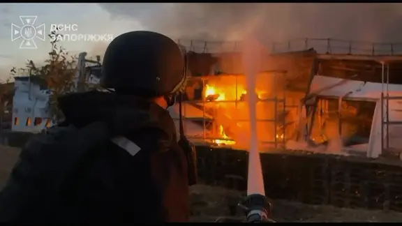 Feuerwehrmann löscht einen Brand in einem Einkuafszentrum nach einem russischen Bombenangriff auf Saporischschja