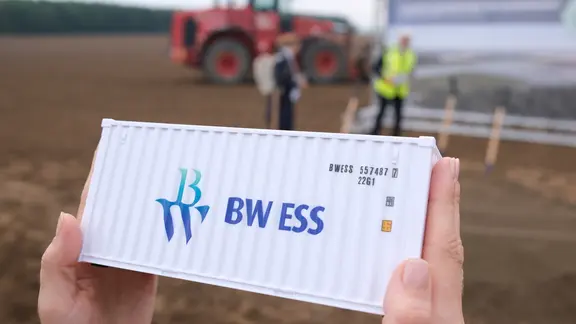 Für ein Foto wird bei einem Festakt das Modell eines Energiespeichercontainers gezeigt.
