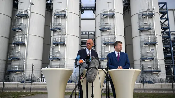 Bundeskanzler Friedrich Merz (l, CDU) und Sven Schulze (CDU), Ministerpräsident von Sachsen-Anhalt, geben ein Statement beim Besuch der Bioraffinerie der UPM Biochemicals GmbH in Leuna ab. (Archiv 3.9.2026)