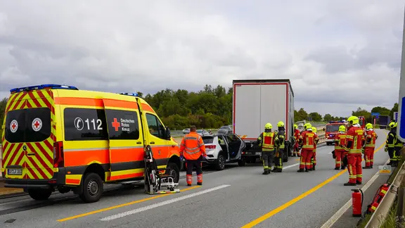 Feuerwehr und Rettungskräfte stehen an einer Unfallstelle