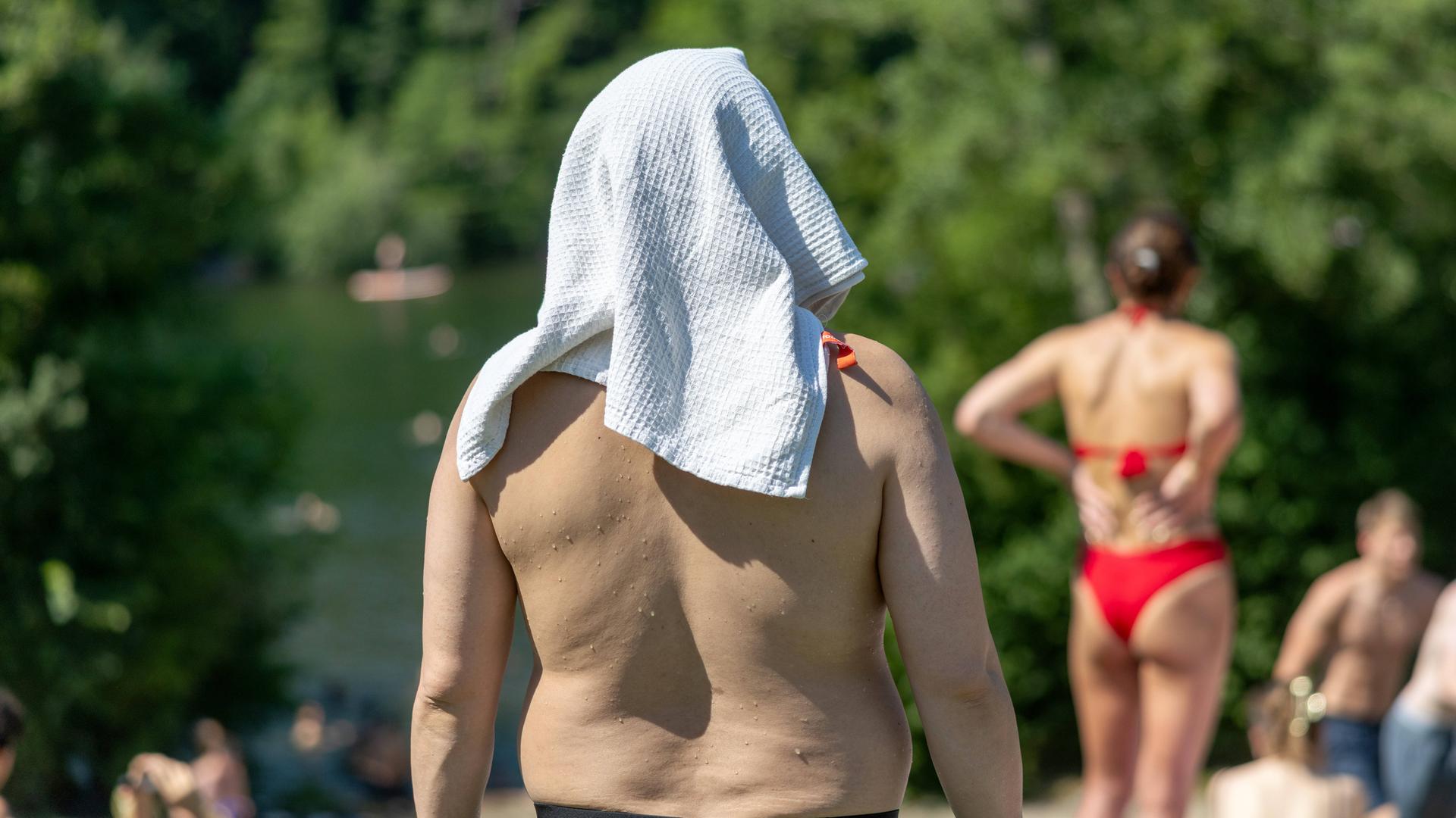 Hitzewelle in Deutschland, Impressionen vom Schlachtensee, Berlin, 27.06.2026 Berlin, Deutschland -27.6.2026: Mann mit Handtuch über dem Kopf bei 38 Grad Celsius am Schlachtensee in Berlin.  | PIC ONE