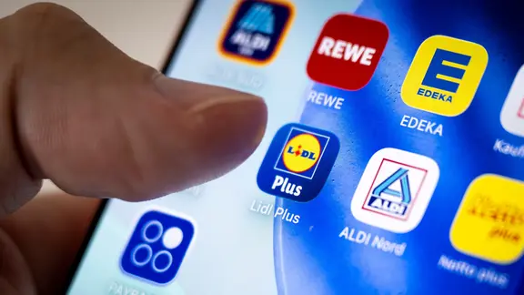 Eine Person tippt in der Lidl Plus App auf ihrem Smartphone.