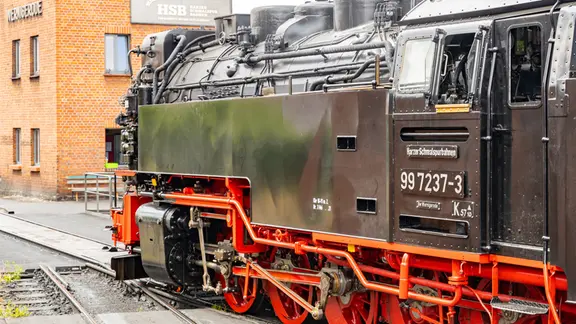 Eine Dampflok der Harzer Schmalspurbahnen steht in Wernigerode auf einem Gleis.