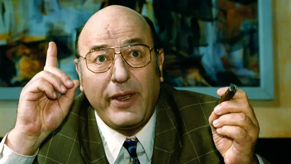 Der Schauspieler Manfred Krug mit erhobenen Zeigefinger und einer Zigarre in der