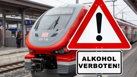 Ein Zug steht am Bahnsteig. Davor steht ein Warnschild mit der Aufschrift "Alkohol verboten!".