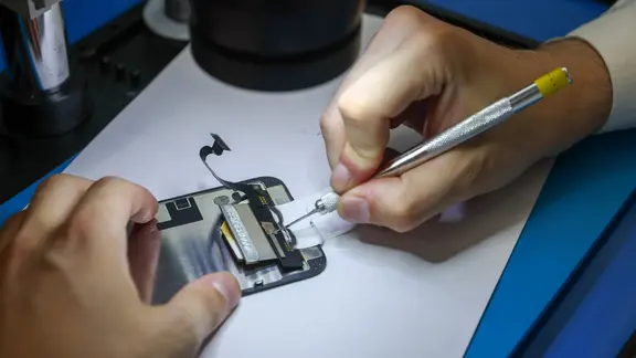 Ein Techniker repariert ein Smartphone.