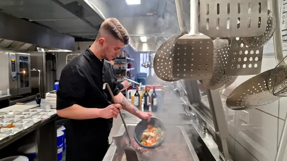 Koch Lucien brät in der Großküche von Monk Catering in Chemnitz Rinderknochen und Gemüse für einen Saucen-Ansatz.