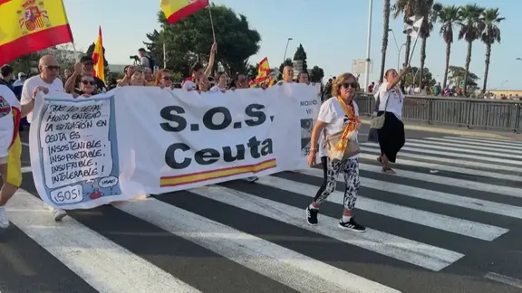 Tausende Menschen protestieren in Spanien gegen die Migrationspolitik der Regierung. Mehrere Menschen halten ein Banner mit der Aufschrift "S.O.S. Ceuta". Ende Juli waren zehntausende Migranten in die spanische Exklave in Nordafrika geströmt. 