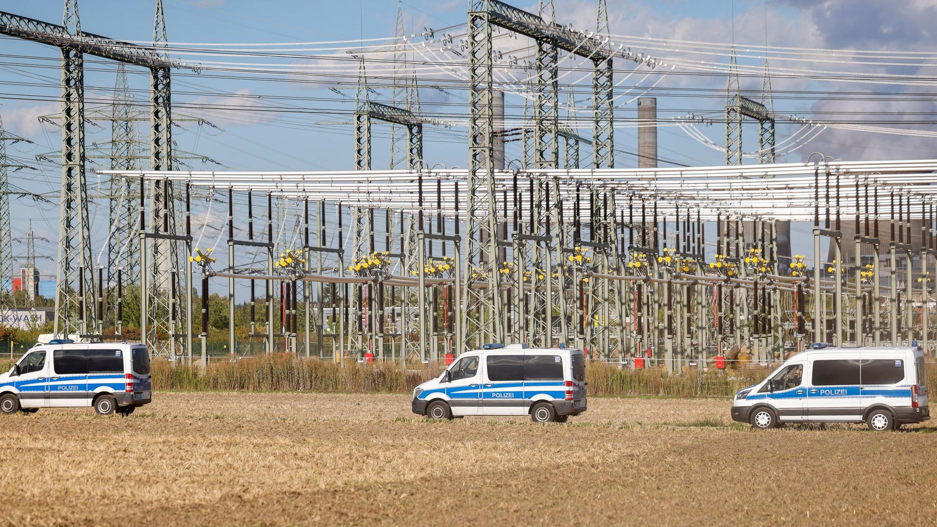 Einsatzfahrzeuge der Polizei fahren vor einem Umspannwerk des Kraftwerks Weisweiler. | picture alliance/dpa | Thomas Banneyer