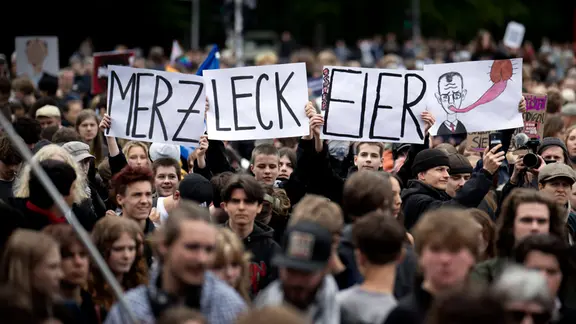 Demonstranten protestieren mit Schild Merz Leck Eier gegen Bundeskanzler Friedrich Merz
