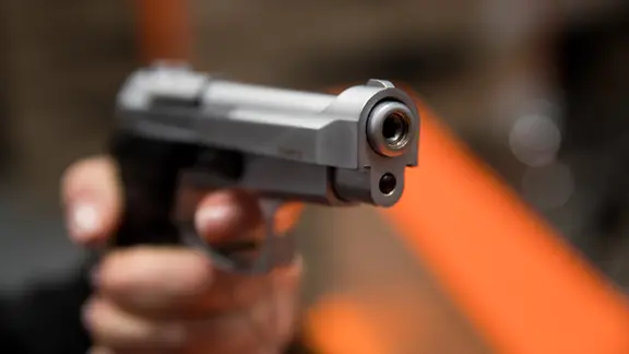 Eine Hand hält eine 9mm Schreckschusswaffe.