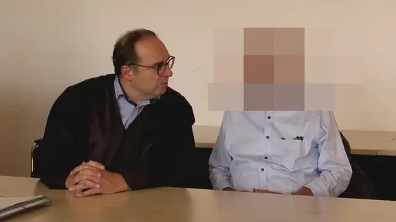 Ein Verteidiger sitzt neben einem Angeklagten.