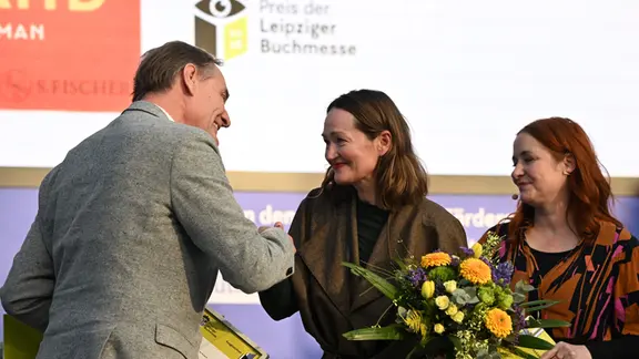 Leipzigs Oberbürgermeister Burkhard Jung (SPD, l) gratuliert Katerina Poladjan (M), Autorin des Buches «Goldstrand», zum Preis der Leipziger Buchmesse in der Belletristik-Sparte.