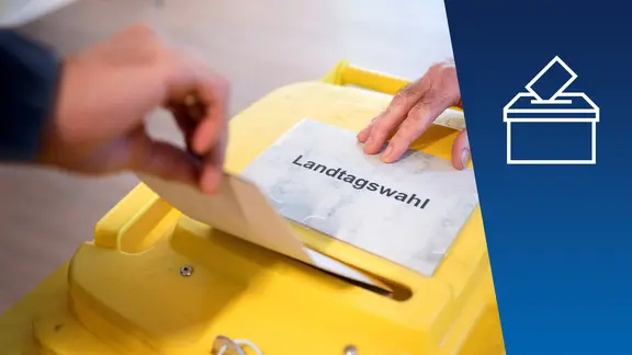 Eine gelbe Wahlurne mit Stimmzettel. 