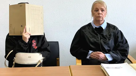 Eine Angeklagte (r.) sitzt neben Henrike Wittner, Rechtsanwältin und Fachanwältin für Strafrecht, zum Prozessauftakt am Landgericht Leipzig.