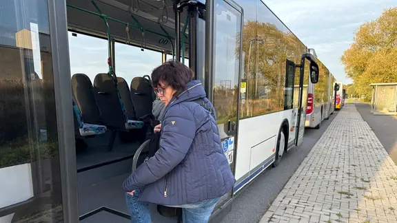 Eine Frau steigt in einen Bus.