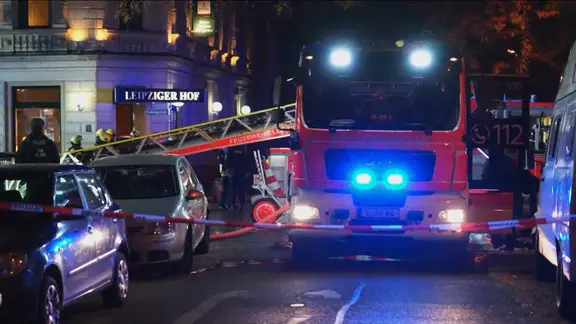 Ein Feuerwehrfahrzeug hat Blaulicht an und steht auf einer Straße in Leipzig zwi