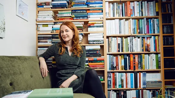 Η Katrin Schumacher ποζάρει για μια φωτογραφία. Στο βάθος υπάρχουν ράφια με βιβλία. | MDR Culture/Hagen Wolf Η Katrin Schumacher ποζάρει για μια φωτογραφία. Στο βάθος υπάρχουν ράφια με βιβλία.