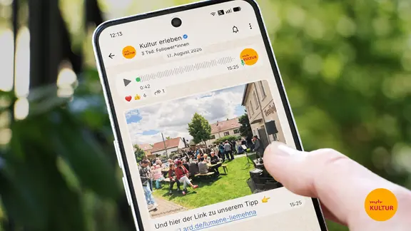 Ein Smartphone auf dem der offene WhatsApp-Chat des MDR KULTUR Kanals zu sehen ist. 