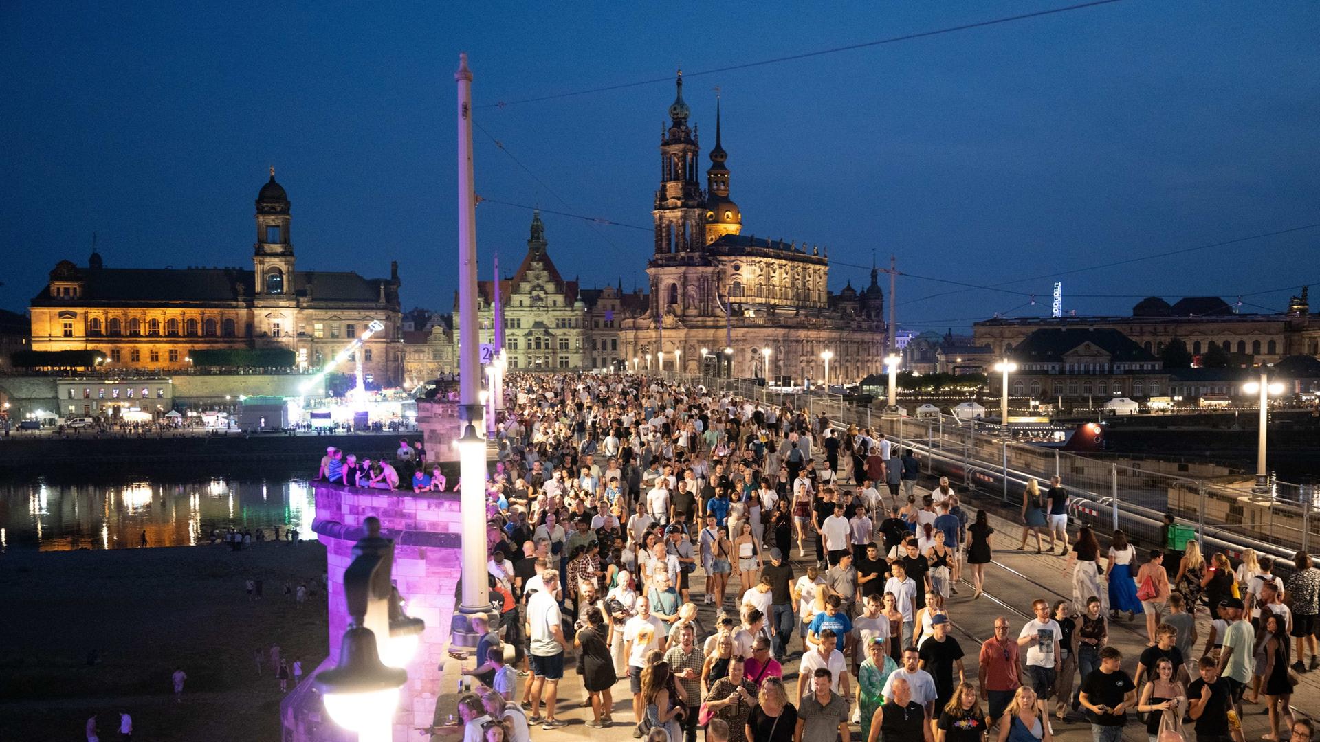 Passanten gehen beim Stadtfest Dresden vor der Kulisse der Altstadt über die Augustusbrücke. | picture alliance/dpa | Sebastian Kahnert