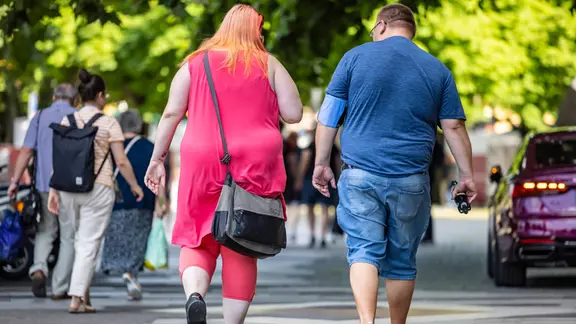 Ein adipöses Paar läuft auf der Straße.
