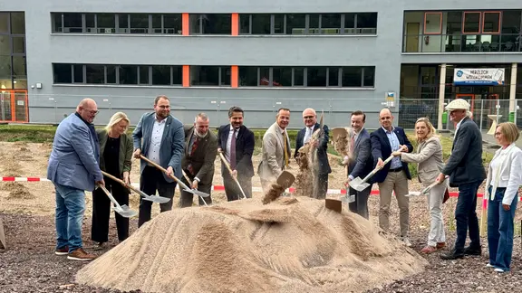 Menschen mit Spaten schaufeln Sand auf einen Haufen