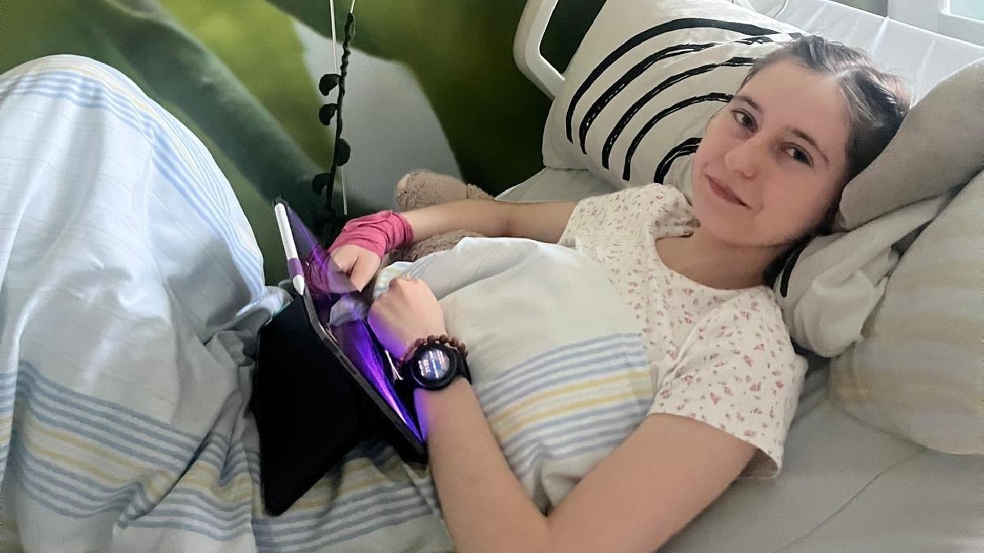 Eine Jugendliche liegt mit einem Computer im Krankenbett  | Carina Muth