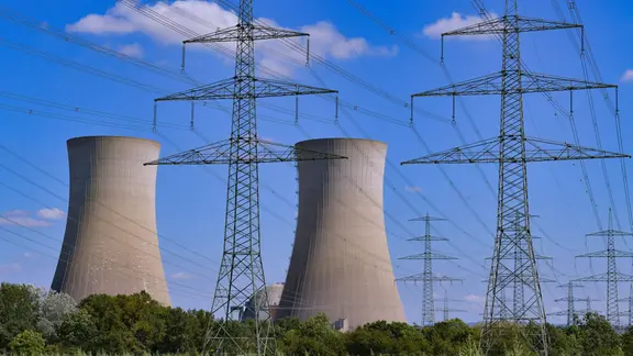 Strommasten und Kühltürme in einer Landschaft