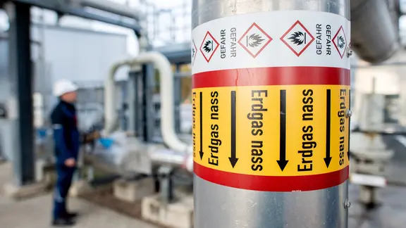 Rohre mit der Aufschrift "Erdgas nass" verlaufen an einer technischen Anlage.