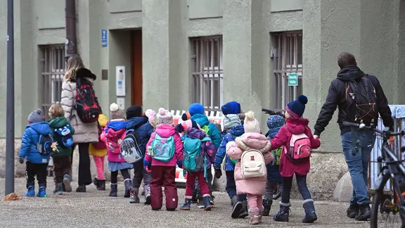 Eine Gruppe Kindergartenkinder mit einem Erzieher und einer Erzieherin macht einen Ausflug
