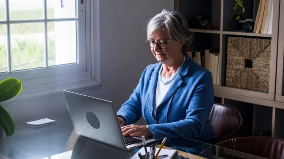 Eine Frau sitzt an einem Laptop.