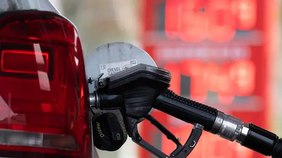 Ein Tankstutzen an einer Tankstelle in der Tanköffnung eines Fahrzeugs.