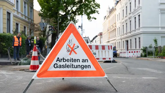 Mitarbeiter der Stadtwerke Görlitz arbeiten vor dem eingestürzten Wohnhaus in der Innenstadt an einer Gasleitung. 