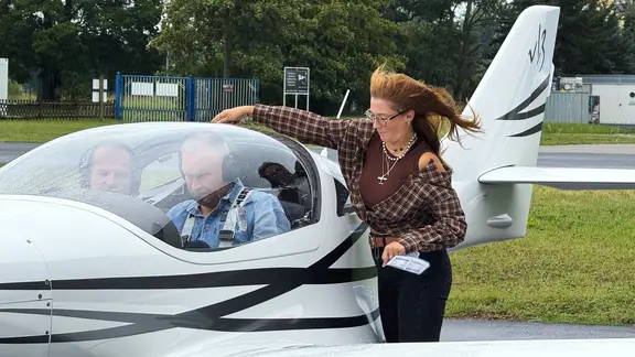 Eine Frau an einem Flugzeug.