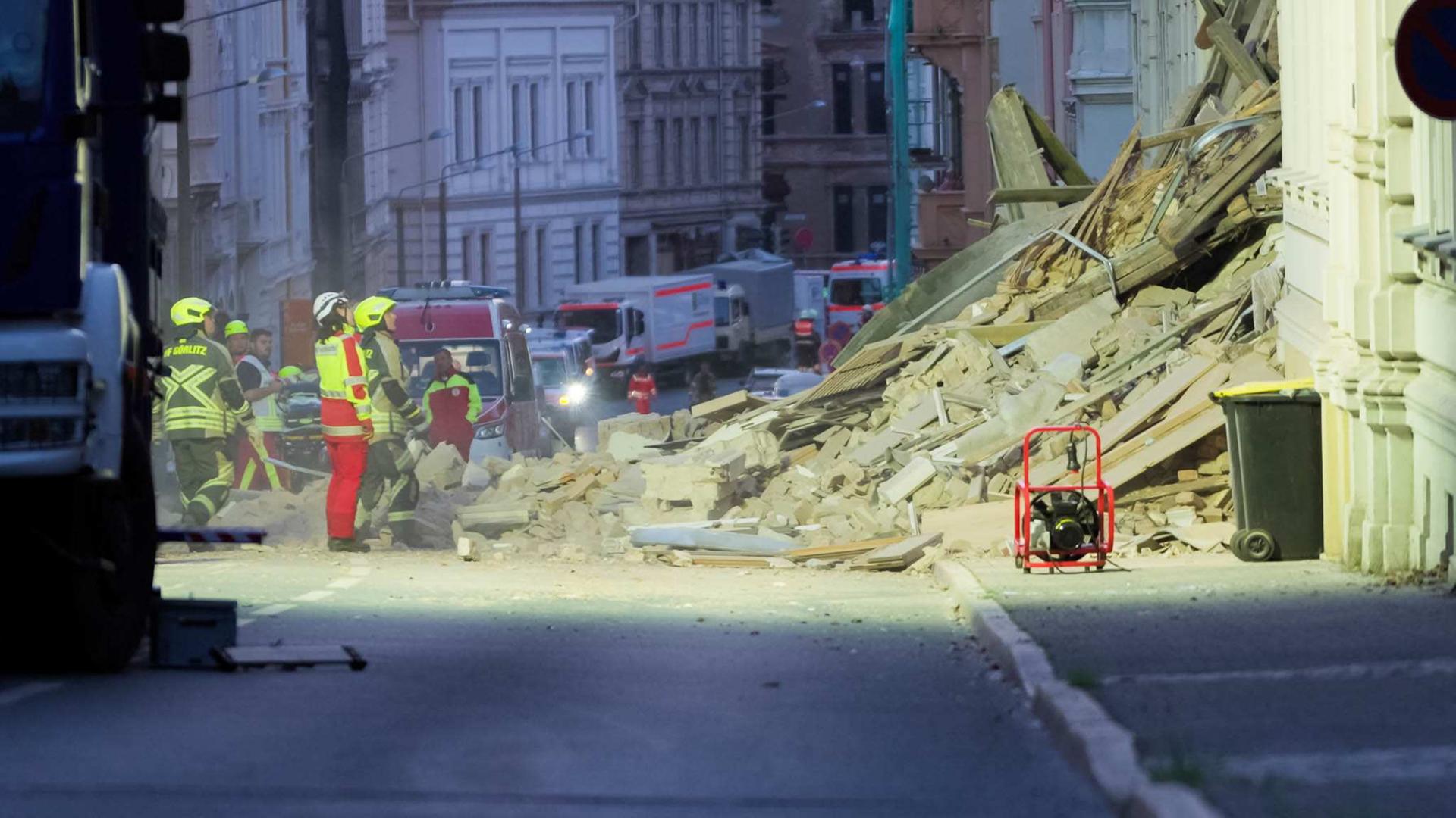 Feuerwehrleute stehen vor einem eingestÃ¼rzten Haus. | xcitepress/Finn Becker