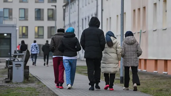 Migranten gehen über das Gelände der Zentralen Erstaufnahmeeinrichtung für Asylbewerber (ZABH) des Landes Brandenburg in Eisenhüttenstadt.