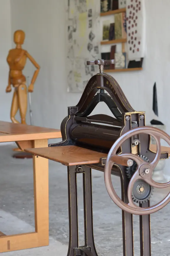 Blick in ein Atelier mit einer Figurine und einem historischen Gerät