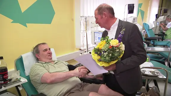 Plasmaspender Ronny Siebert bekommt einen Blumenstrauß 