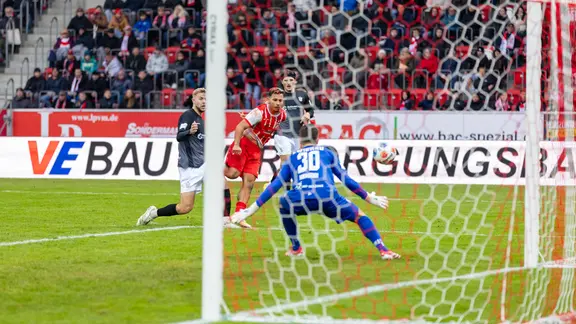 Ein Fußballspieler setzt sich gegen die gegnerische Abwehr durch und schießt aufs Tor (Sejdo Durakov, FC Rot-Weiß Erfurt, Torwart Lucas Hiemann. FSV Zwickau).