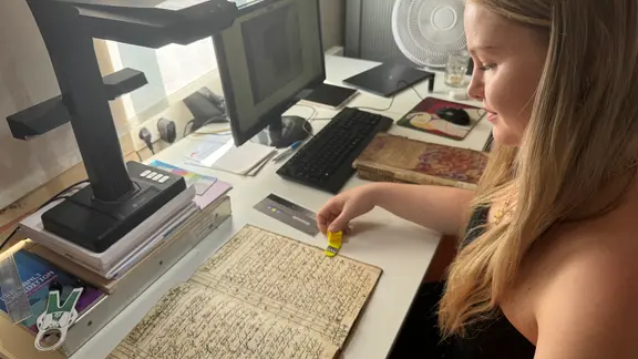 Doktorantin Jennifer Penzler vor historischen Akten