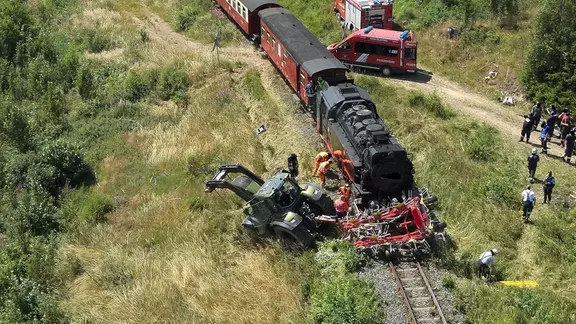 Rettungseinsatz neben einer Bahnstrecke. Ein Zug ist mit einem Traktor kollidiert.