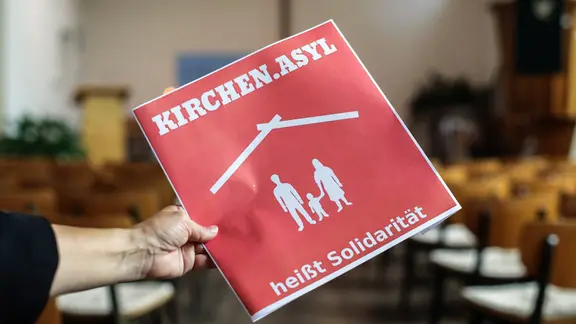 Schild mit der Aufschrift "Kirchenasyl heißt Solidarität" in einer evangelischen Kirche.