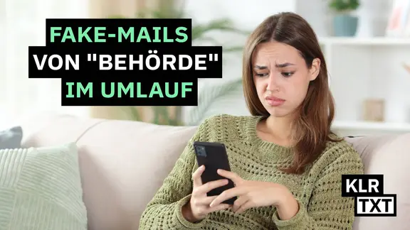 Frau schaut genervt auf ihr Handy.