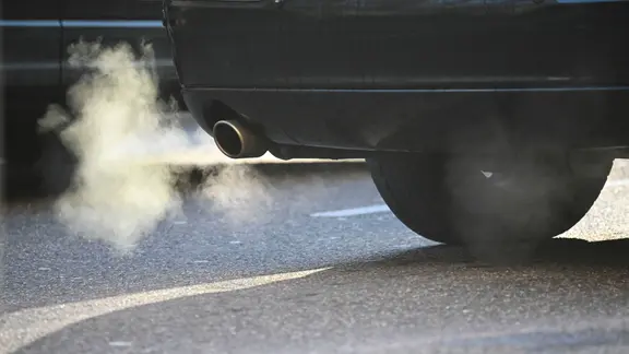 Weißer Rauch ist hinter einem Kraftfahrzeug im Straßenverkehr zu sehen. (zu dpa: «Verbrenner-Aus 2030? BGH prüft Klimaklagen gegen Autobauer»)